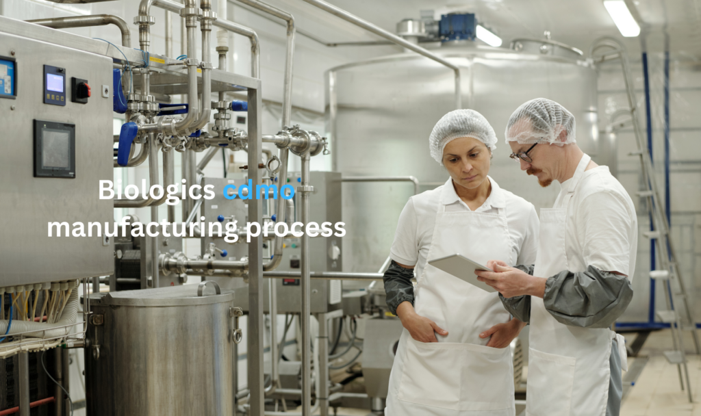 Biologics CDMO manufacturing process showing pharmaceutical professionals reviewing production data inside a biologics manufacturing facility.